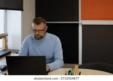 Person working at desk with laptop in home office environment