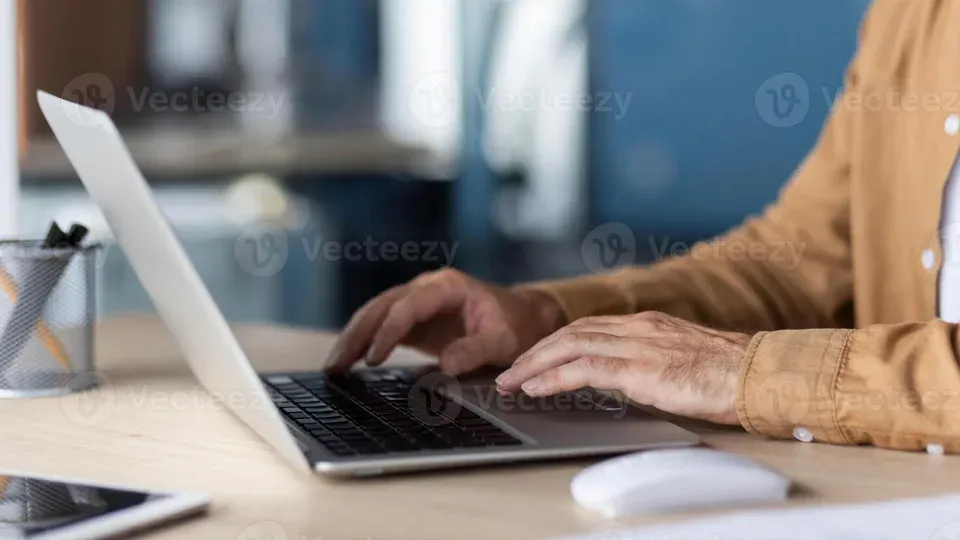 Hands typing on keyboard at a desk workspace