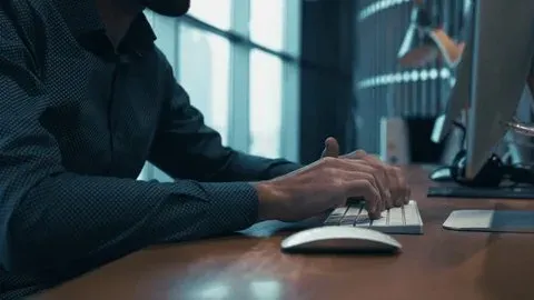 Hands typing on keyboard at a professional workspace desk