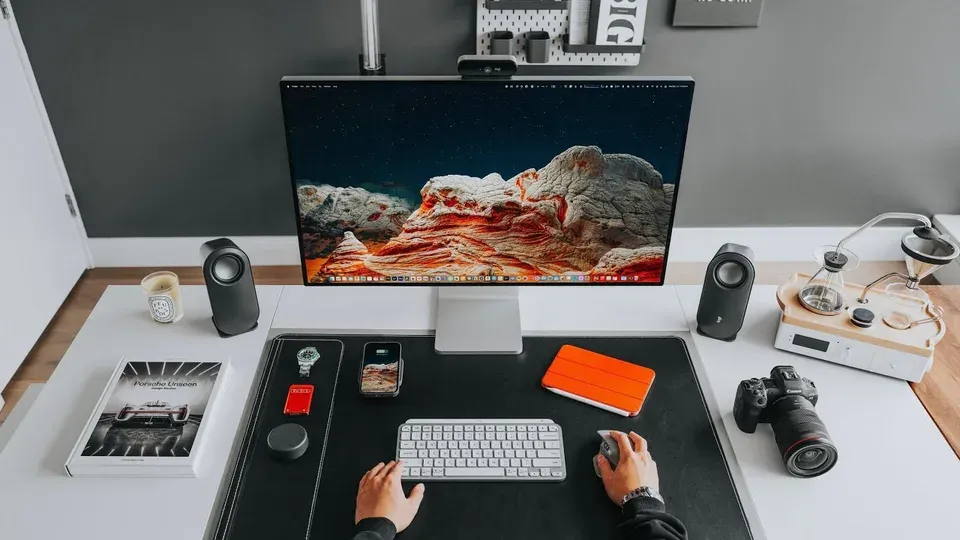 Hands typing on keyboard at professional workspace desk