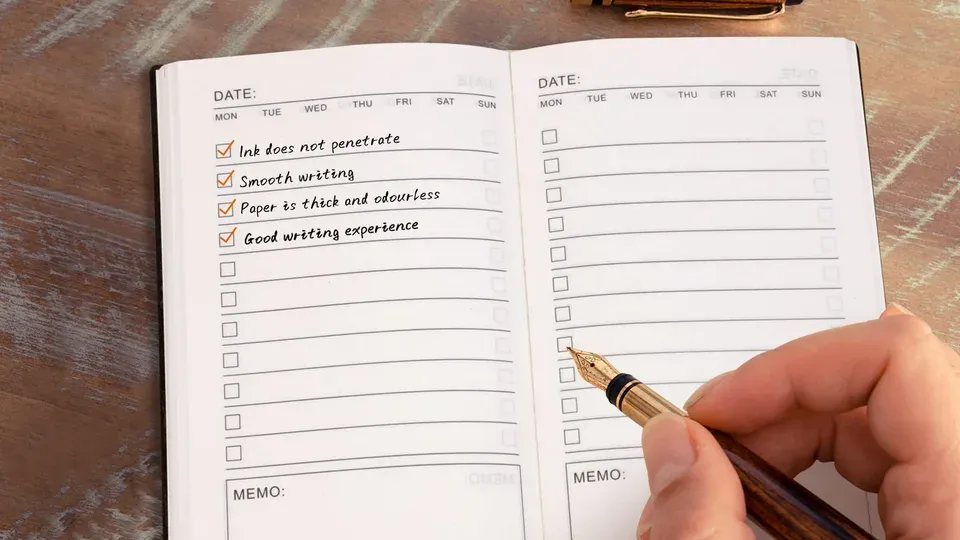 Overhead view of notebook with pen and checklist for planning and organization
