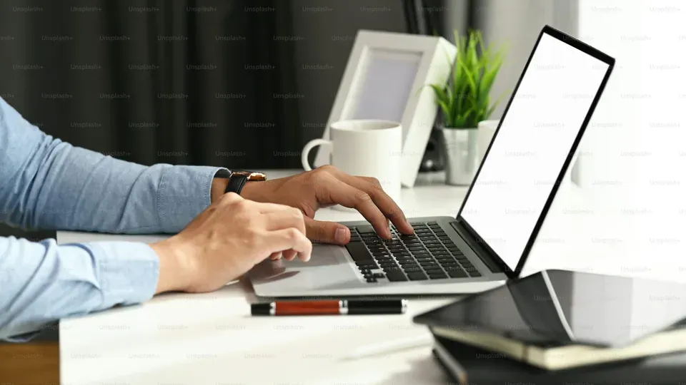 Hands typing on keyboard at desk during active work session