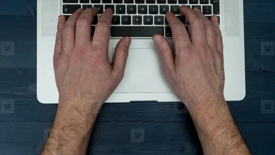 Hands typing on laptop keyboard during SEO work session