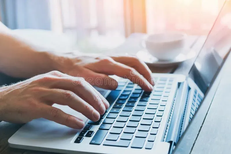 Close-up of hands typing on keyboard during focused work session