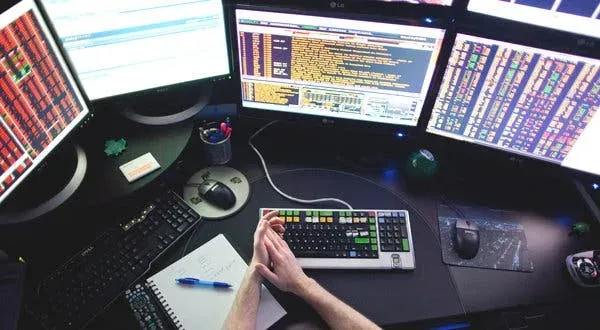 Multi-monitor setup displaying various data dashboards and analytics