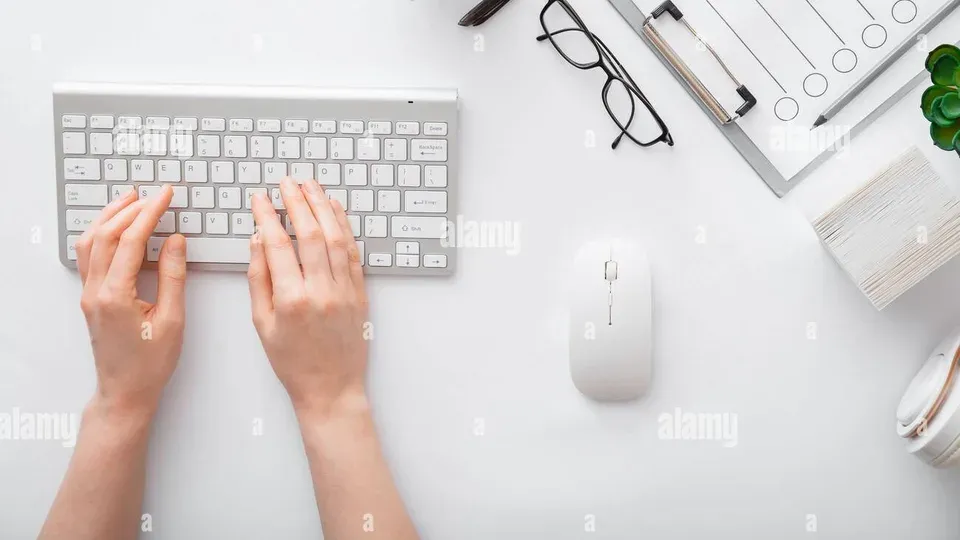 Hands typing on keyboard at a professional workspace desk