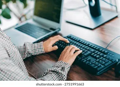 Hands typing on keyboard at a professional workspace desk
