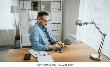 Professional working at laptop in a well-lit modern workspace