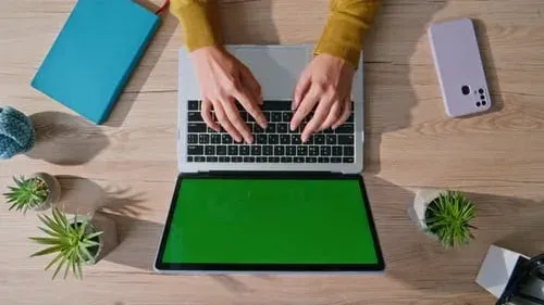 Close-up of hands typing on a keyboard at a workspace desk